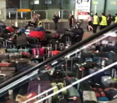 Suitcases piled up outside a terminal at Heathrow Airport in London